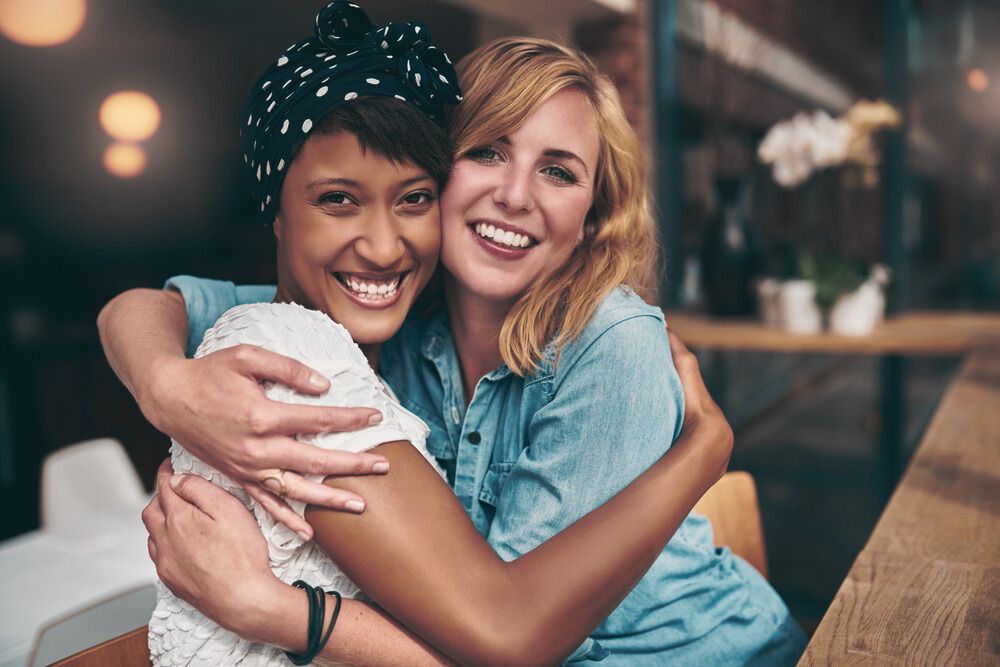 two women hugging after completing addiction treatment program