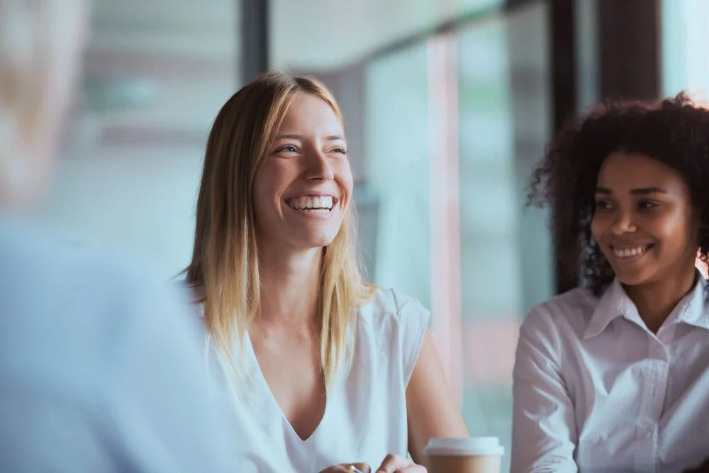 woman smiling and sharing in addiction recovery support group